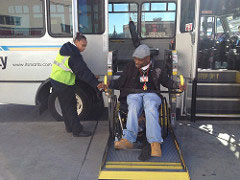 man getting off a bus using a lift